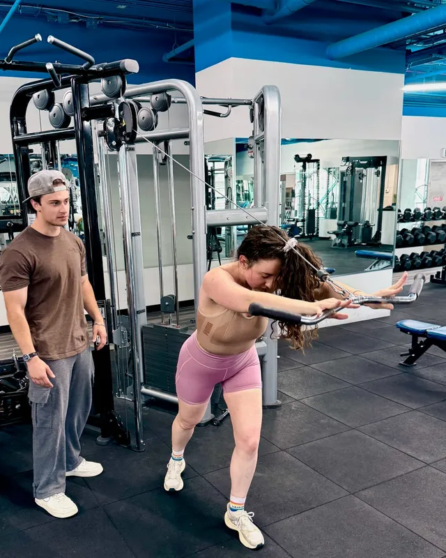 Boston Adams coaching a client through a standing cable rotation