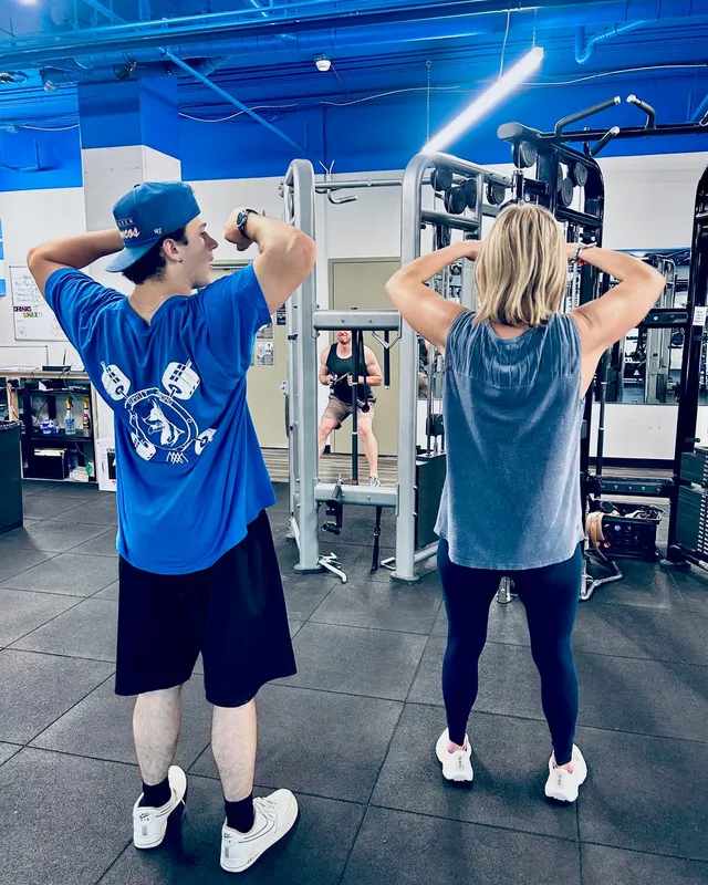 Boston Adams leading a client through an overhead mobility movement