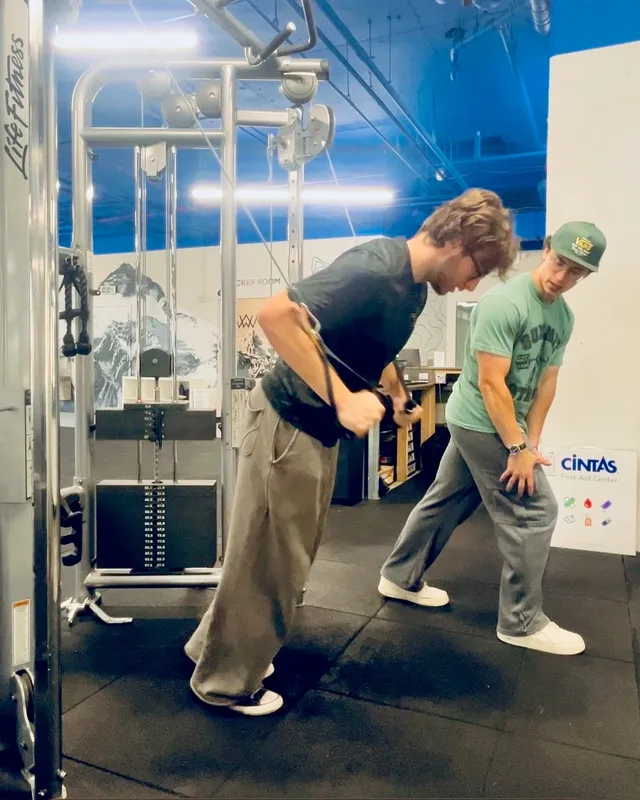Boston Adams coaching a client through a resistance-band row